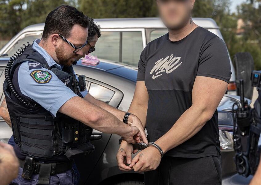 NSW police officer applying handcuffs on perp